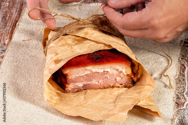 Fototapeta smoked meat wrapped in wrapping paper and tied with twine