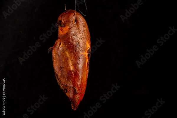 Fototapeta smoked chicken white meat in the process of smoking on a black background