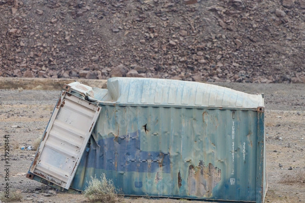 Fototapeta a container tossed on the side of a road in the African desert