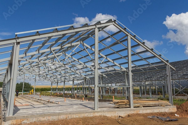 Fototapeta Steel frame of a building under construction. The construction of the building is made of steel beams. Construction of prefabricated structures