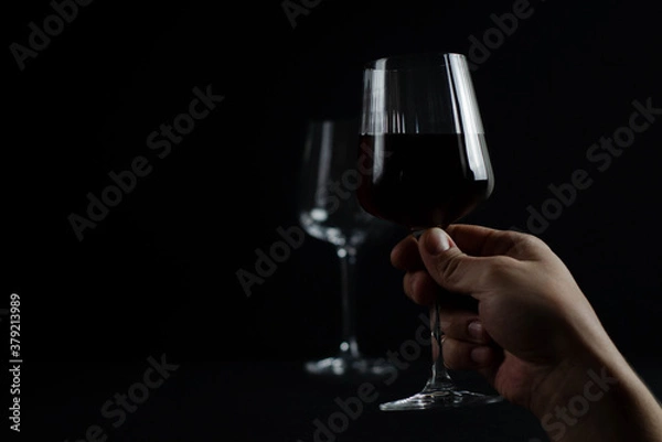 Fototapeta glasses with red wine on a dark background. photograph of wine in a low key.