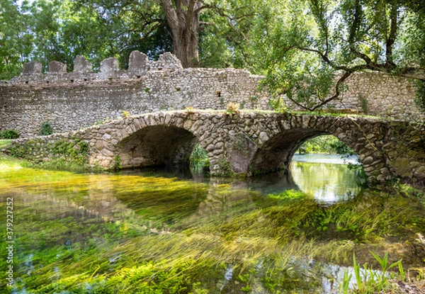 Fototapeta Garden of Ninfa and ruins of the medieval city Ninfa in Italy in the province of Latina. Most beautiful and romantic gardens in the world.