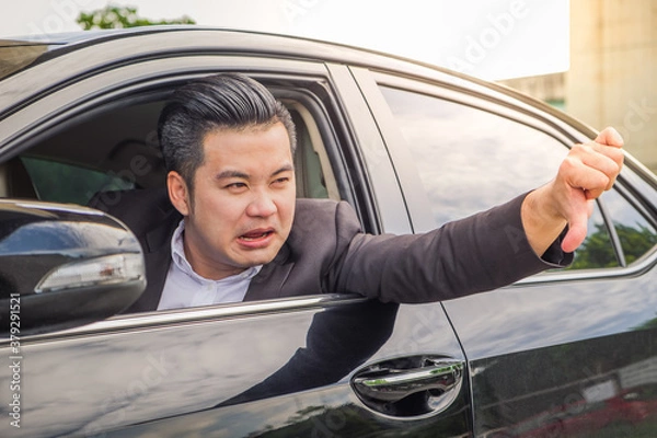 Obraz Portrait of businessman unhappy using smartphone calling for assistance with his car broken down by the roadside. Young Asian man disappointed while driving automobile commute to work on the road trip