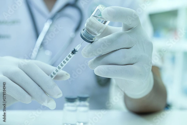 Fototapeta A scientist is holding a tube of vaccine and a syringe. Concept of against virus COVID-19 coronavirus,  a syringe with liquid vaccines adults, diseases, medical care, science.