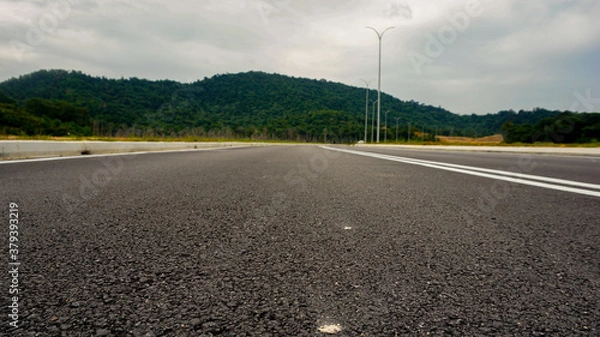 Fototapeta low angle shot of asphalt road and mountain in background in Malaysia