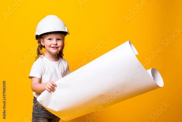 Obraz Little girl architect in the construction helmet with a poster isolated on yellow background