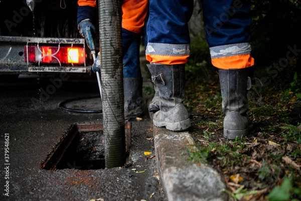 Fototapeta Cleaning storm drains from debris, clogged drainage systems are cleaned with a pump and water