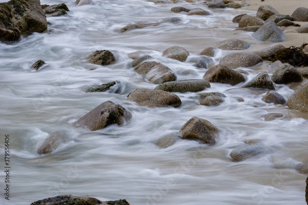 Obraz Long exposure Pacific seascape waves on the rocky stoney shore. Slow shutter speed used to see the movement (Soft focus shot)
