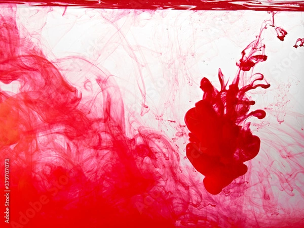 Fototapeta Closeup of a red ink in water in motion isolated on white. Ink swirling underwater. Colored abstract smoke explosion effect. Abstract background with copy space..