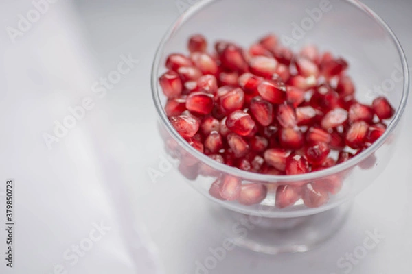 Fototapeta Pomegranate grain macro photography. Pomegranate seeds in a glass bowl close up. Peeled pomegranate in a transparent vase on the table. Ready-to eat.