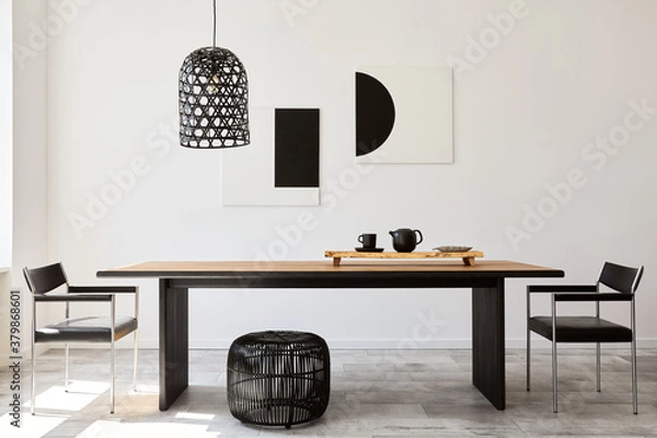 Fototapeta Stylish dining room interior with design wooden family table, black chairs, teapot with mug, mock up art paintings on the wall and elegant accessories in modern home decor. Template.