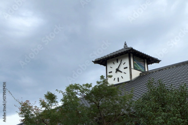 Fototapeta 青空に伸びる屋根の上の時計