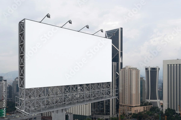 Fototapeta Blank white road billboard with KL cityscape background at day time. Street advertising poster, mock up, 3D rendering. Side view. The concept of marketing communication to promote or sell idea.