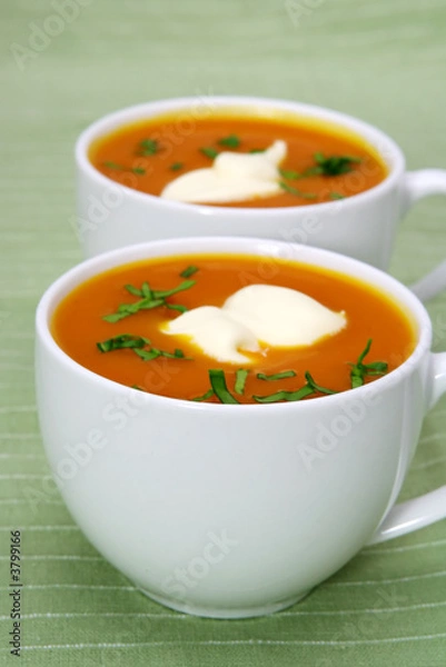 Fototapeta Fresh pumpkin soup in white cups, on green background.