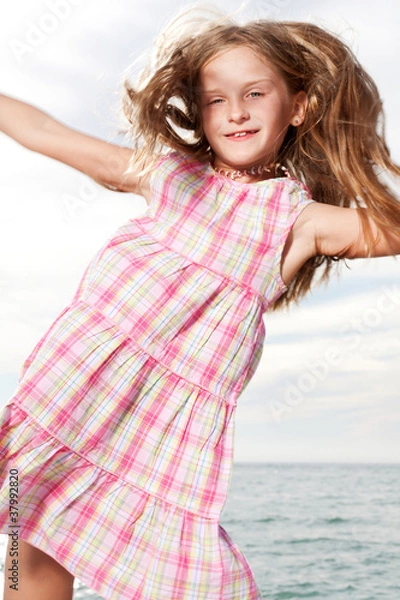 Fototapeta Girl enjoys summer day at the beach.