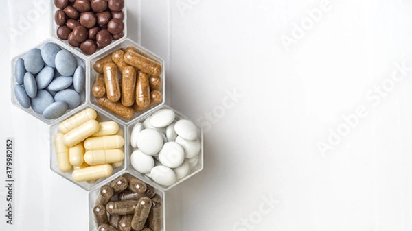 Fototapeta Various capsules and pills with dietary supplements or medicines in hexagonal jars