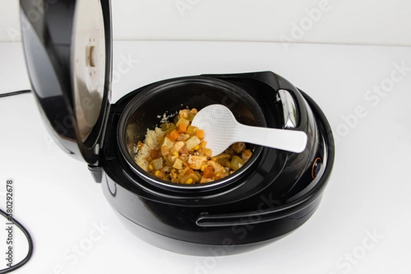 Obraz Macro video of a multicooker. The man opens the pan and mixes the dish. The concept of cooking automation and ease in the kitchen.