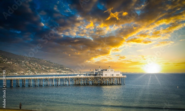 Obraz Molo w Malibu pod zachmurzonym niebem o zachodzie słońca