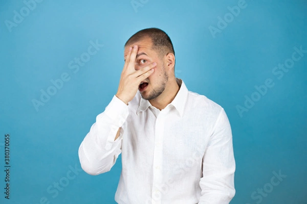 Fototapeta Russian business man wearing white shirt standing over blue background with sad and fear expression. Embarrassed and negative concept.