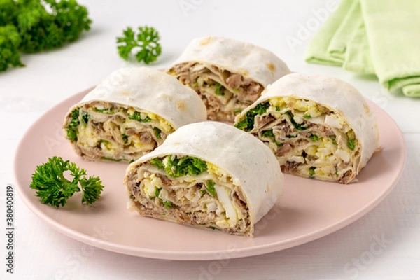 Fototapeta Lavash roll with fish, cheese, eggs and parsley on white background. Festive appetizer.