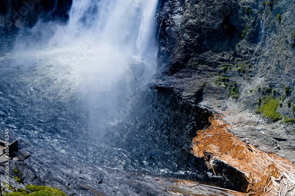 Obraz waterfall in the forest with logs
