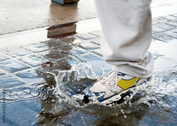 Fototapeta Man stepping into a pool of water in a rush 
