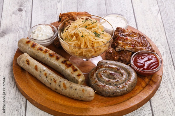 Fototapeta Meat plate with grilled sausages, ribs and chicken wings
