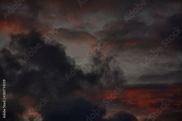 Obraz Black wispy clouds and red skies at sunset in Autumn