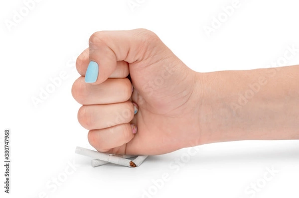 Fototapeta Stop smoking concept. Woman's fist breaks cigarettes on white background.