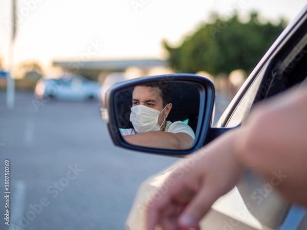 Fototapeta Reflejo en espejo retrovisor de un hombre con mascarilla