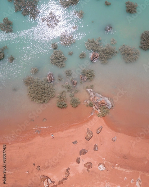 Fototapeta Drone view of red sand beach and turquoise water