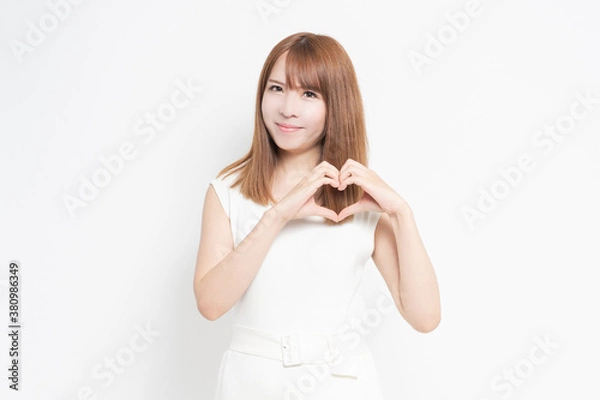 Fototapeta 手でハートの形を作る若い女性