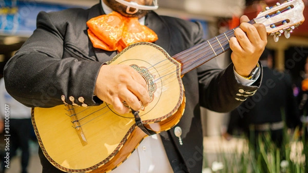 Fototapeta Mariachi Playing a Mexican Vihuela with Blurry Pedestrians as Background