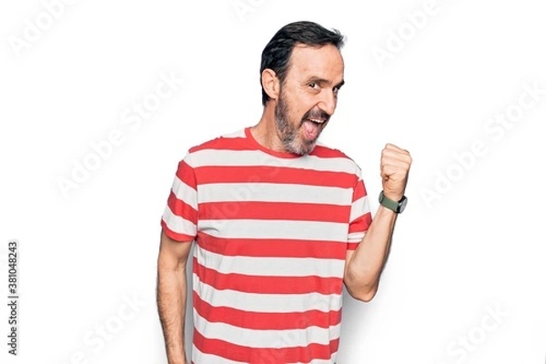 Fototapeta Middle age handsome man wearing striped t-shirt standing over isolated white background pointing thumb up to the side smiling happy with open mouth