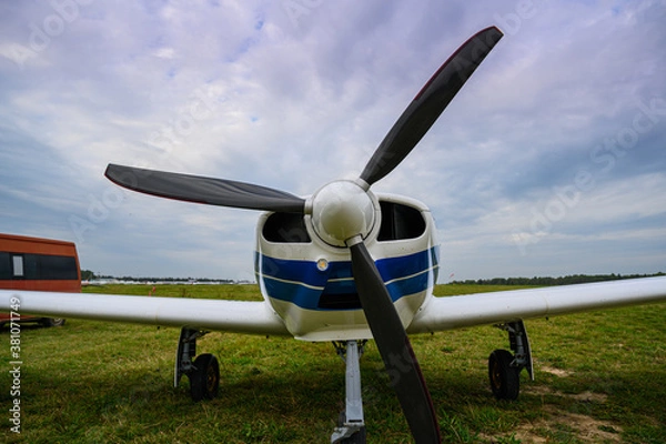 Obraz small single-engine civil airplane on a green grass of a countryside airdrome