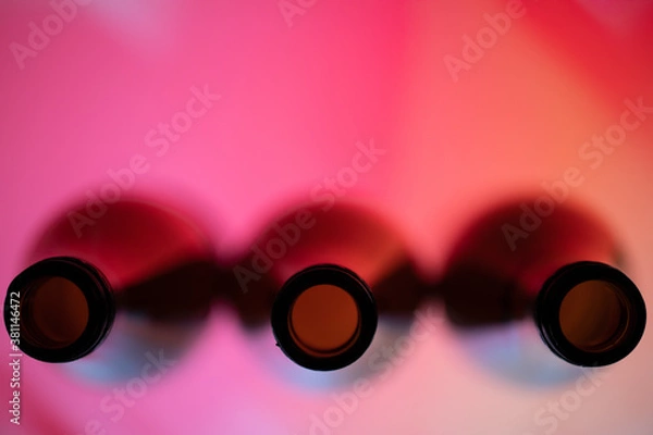Obraz Three wine bottles viewed from top in a red background