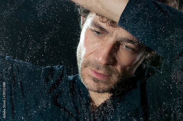 Obraz Trauriger Mann hinter nasser Fensterscheibe
