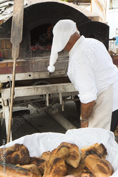 Fototapeta Boulanger travaillant avec un four à bois