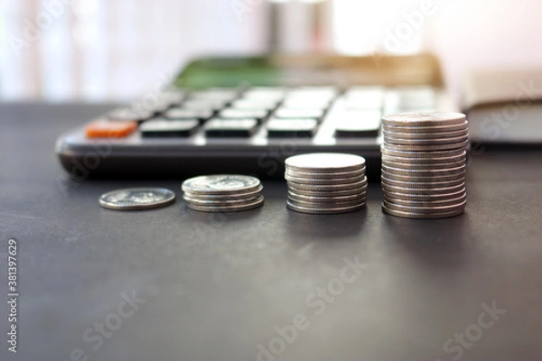 Fototapeta Closeup stack coin for growing business and calculator on the table. Concept of finance and business.