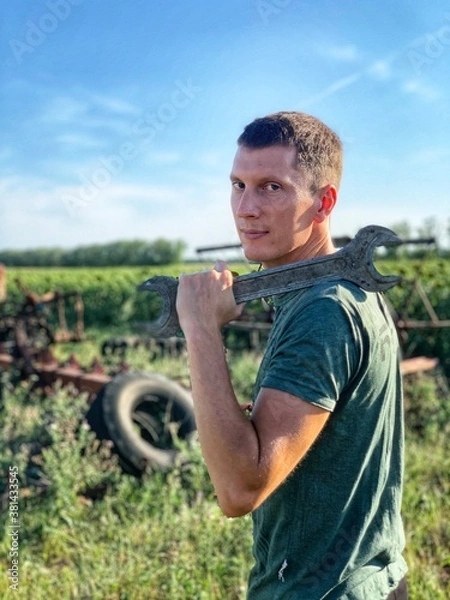 Obraz Young smiling handsome man with wrench outdoor