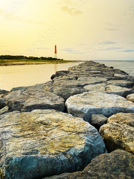 Obraz Lighthouse with ocean line horizon and stones bay