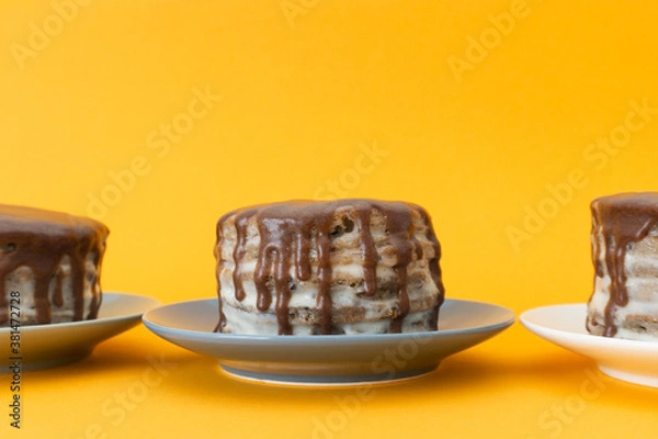 Obraz Chocolate cake on a plate with flows down. Halloween concept, trick or treat. Orange background, handmade cooking. Brownies with cream. Copy space. Selective focus, blur.