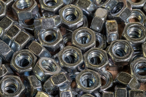 Fototapeta A pile of hex nuts on a workbench