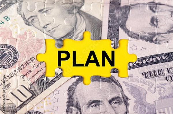 Fototapeta Puzzle with the image of dollars in the center of the inscription -PLAN