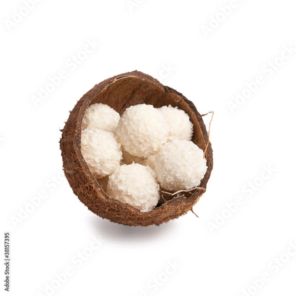 Fototapeta white chocolate truffles in a box of coconut halves isolated on