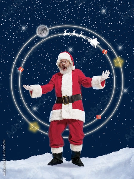 Fototapeta Emotional Santa Claus greeting with New Year 2021 and Christmas on outter space and stars background. Caucasian man in traditional costume. Concept of holidays and winter mood. Copyspace. Kind Nicolas