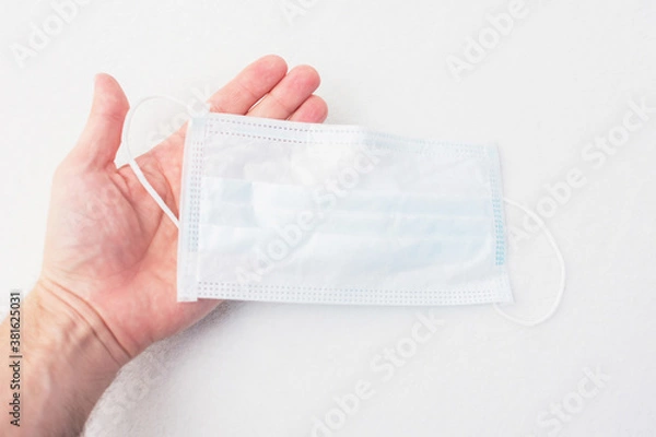 Fototapeta Hand with medical mask, hand close up, cropped image, copy space
