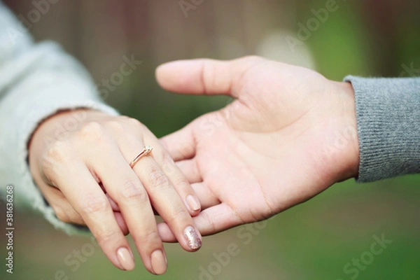 Fototapeta Women and man wear a ring in the finger holding hands together, Happy love in the garden. romantic atmosphere in the parks. concept couple lover valentine day. shake hands