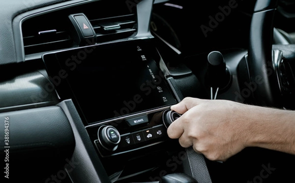 Fototapeta Man turning on car air conditioning system. Hand of man turning on car air conditioning system,Button on dashboard in car panel,Auto air conditioning.