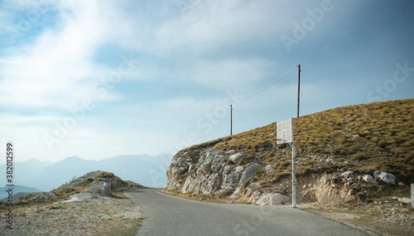 Fototapeta Basketball ring in the middle of nowhere. Basketball ring with random stickers from travelers stand alone by the serpentine road on top of Durmitor mountain in Montenegro.